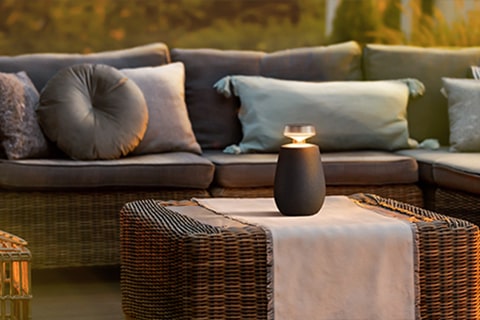 LG XBOOM 360 XO2T steht auf einem Tisch im Freien.